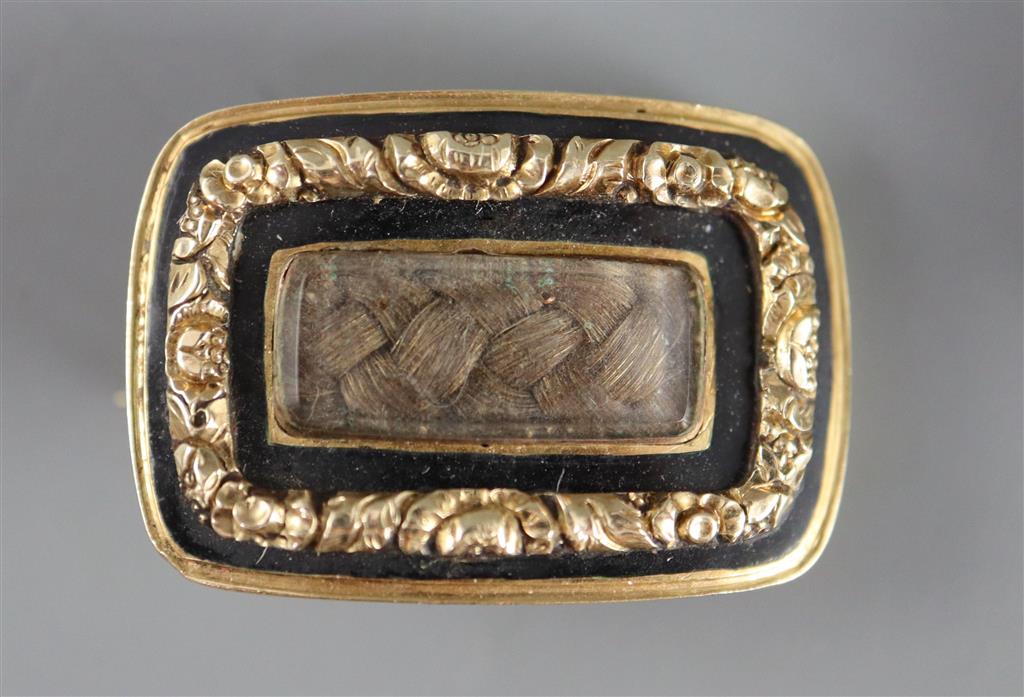 A George III gold and black enamel memorial ring with hairwork panel and a matching brooch,